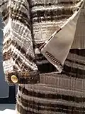 A 1965 Chanel suit showing the chain that is a distinctive technique for constructing a Chanel suit. It gives even light-weight materials a good drape and stabilize the suit as it weighs down the hem.[118][119]