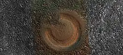 Close view of mud volcano, as seen by HiRISE. Picture is about 1 km across. This mud volcano has a different color than the surroundings because it consists of material brought up from depth. These structures may be useful to explore for remains of past life since they contain samples that would have been protected from the strong radiation at the surface.