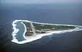 An airstrip and a red and white antenna mast on a small, green, triangular island