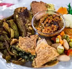 Speca të fërguar (roasted peppers) served with pite, a traditional and prominent layered Albanian pie