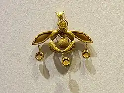 The Bee Pendant, an iconic Minoan jewel; 1700–1600 BC; gold; width: 4.6 centimetres (1.8&nbsp;in); from Chrysolakkos (gold pit) complex at Malia; Archaeological Museum of Heraklion (Heraklion, Greece)[44][45]