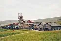 A collection of brick-and-mortar structures on a grassy hillside