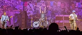 Blink-182 performing in Palm Desert in 2025. Left to right: Mark Hoppus, Travis Barker, and Tom DeLonge