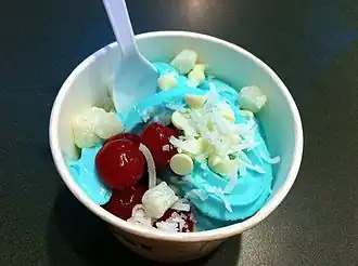 Blue raspberry frozen yogurt with white chocolate chips, coconut, and cherries.