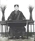 Upper Class Man Sitting at a Table Playing the Qin, 1906–1912.