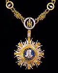 A gold and silver-coloured medal depicting the silhouette of a man.