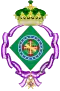 Coat of arms consisting of a shield with a green field with a golden armillary sphere over the red and white Cross of the Order of Christ, surrounded by a blue band with 19 silver stars; the bearers are two arms of a wreath, with a coffee branch on the left and a flowering tobacco branch on the right; and above the shield is an arched golden and jeweled crown
