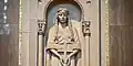 St. Kateri Tekakwitha, wearing a shawl mantle, holds a wooden cross in her hands.
