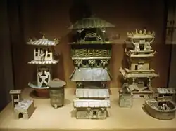 Among a large set of architectural models, three Eastern Han dynasty watchtowers stand in the rear of this display.