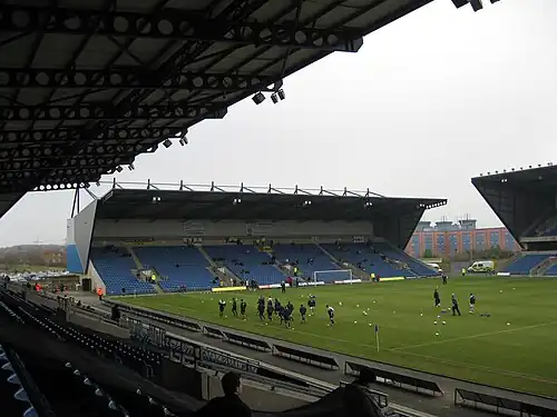 A grandstand at a sports stadium. The seats are predominantly red.