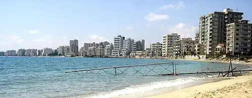 Abandoned high-rise buildings along a fenced-off beachfront in Varosha