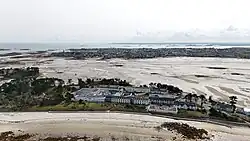 Aerial photograph of a hospital complex in Roscoff, France, located beside wide coastal tidal flats.