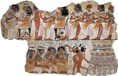 Painting of elaborately dressed men and women. Some women clap and play flutes while others dance.