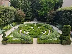Geometric French garden with boxwood hedges, flower beds, and shaped topiary at Hôtel de Caumont in Aix-en-Provence.