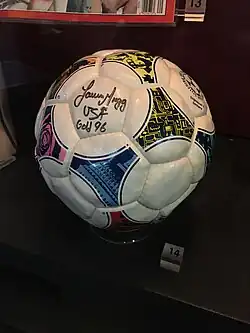 A soccer ball with a signature on one of the hexagonal panels.