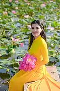 A woman wearing yellow Áo dài