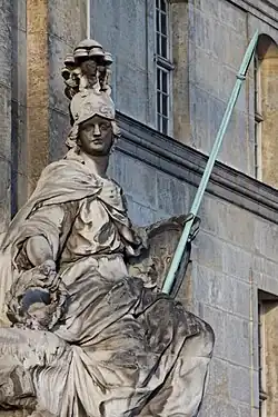 The portal is guarded by a statue of the Goddess Minerva