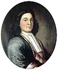 A head and shoulders portrait of Phips. He has dark hair, and wears a magistrate's robe.