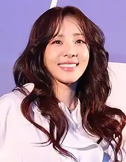 Park in a white shirt facing the viewer