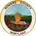 A round seal featuring a sheaf of grain in a field with a white border