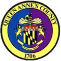 A round seal featuring heraldic elements on a blue-and-purple background with a yellow border
