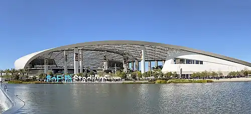 Exterior view of SoFi Stadium from across Rivers Lake in April 2023