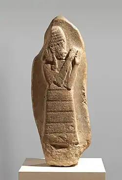 Stone stele with carved relief showing protective goddess Lama with inscription