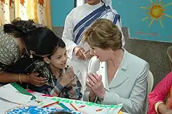 The first lady of the USA Laura Bush interacting with a child on her visit to the Mother Teresa Light of Life Home (Jeevan Jyothi) for disabled children in New Delhi on 2 March 2006.
