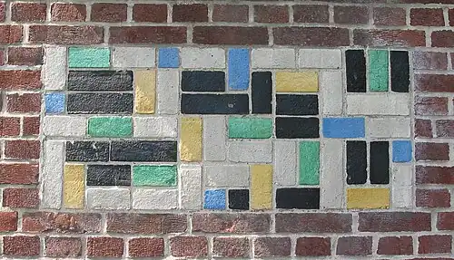 De Stijl&nbsp;– Panel of polychrome bricks on the exterior of the Vakantiehuis De Vonk&nbsp;[nl], a house in Noordwijkerhout, the Netherlands, by Theo van Doesburg, 1917–1919[71]
