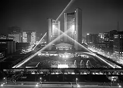 two curved towers lit by searchlights