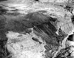Dark-colored mass of rock draped over the side of a canyon