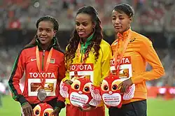 Three women are standing at the podium of the 2015 World Championship. Hassan is on the right with a bronze medal.